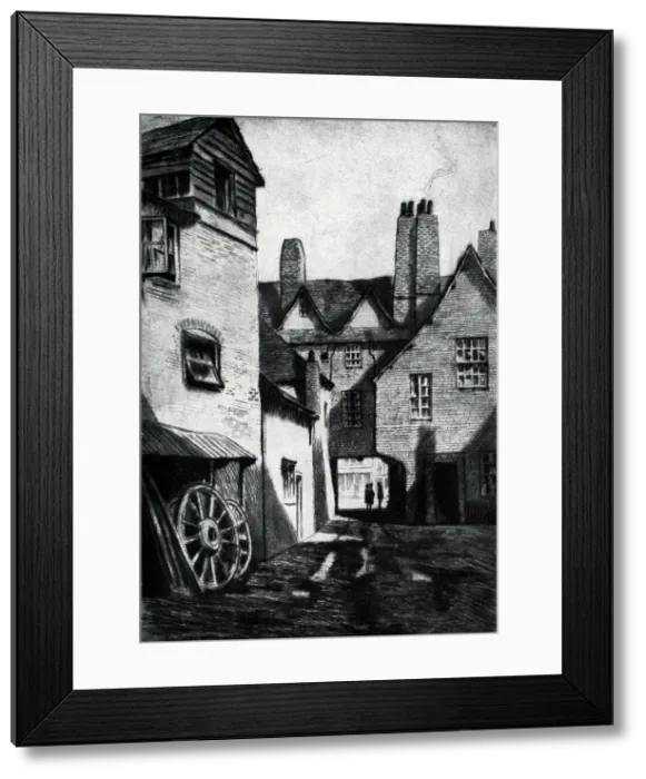 Framed Print : An etching of some houses in Marlborough, Wiltshire. Some large wagon wheels can be seen leant against the closest building. Date: circa 1930 Framed Print : An etching of some houses in Marlborough, Wiltshire. Some large wagon wheels can be seen leant against the closest building. Date: circa 1930