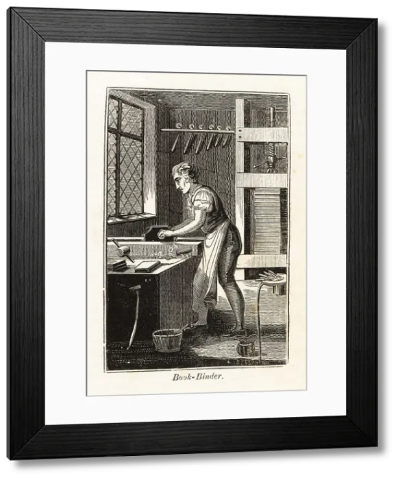 Framed Print : Book-binder planing a book block in a bindery Framed Print : Book-binder planing a book block in a bindery