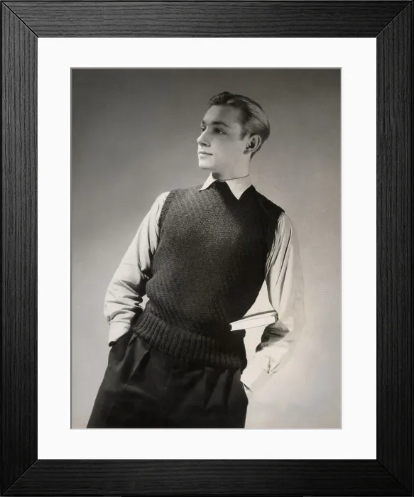 Framed Print : A studious young man with a book under his arm wears a vest or sleeveless knitted top in a stitch that produces a decorative diagonal stripe. Date: 1950's Framed Print : A studious young man with a book under his arm wears a vest or sleeveless knitted top in a stitch that produces a decorative diagonal stripe. Date: 1950's