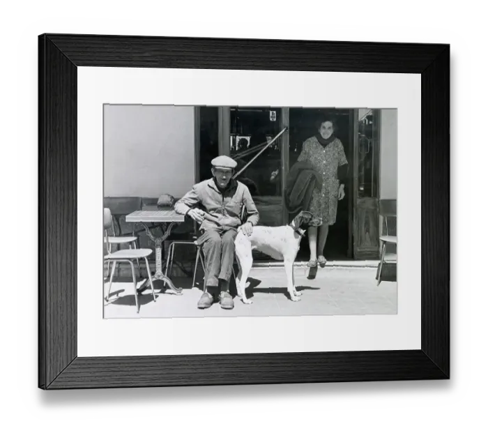 Framed Print : An older man with his pet dog seated at a small table on a terrace outside a cafe or restaurant in the south of France. Date: circa 1970s Framed Print : An older man with his pet dog seated at a small table on a terrace outside a cafe or restaurant in the south of France. Date: circa 1970s