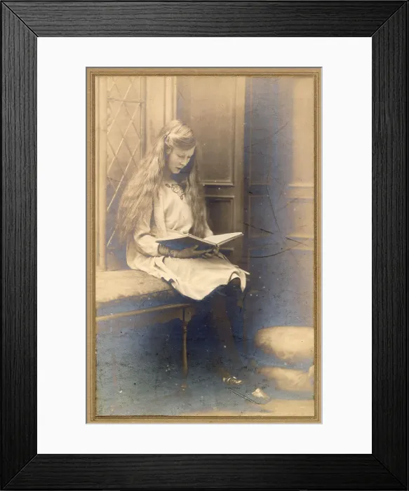 Framed Print : Young woman with long hair in a window seat reading a book Date: circa 1910s Framed Print : Young woman with long hair in a window seat reading a book Date: circa 1910s
