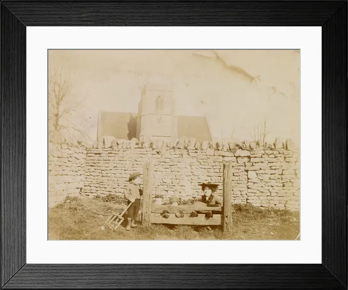 Framed Print : Woman and three boys in or by the stocks, possibly in Oxfordshire, with a church in the background. Date: circa 1890 Framed Print : Woman and three boys in or by the stocks, possibly in Oxfordshire, with a church in the background. Date: circa 1890