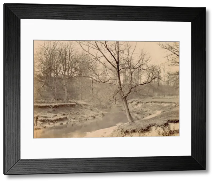 Framed Print : Woolfe family of The Clough, Hale, Bucklow, Cheshire - boy standing by the River Bollin, with bare trees indicating autumn or winter. Date: circa 1889