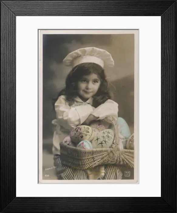 Framed Print : Little girl in chefs costume with a basket of painted eggs Framed Print : Little girl in chefs costume with a basket of painted eggs