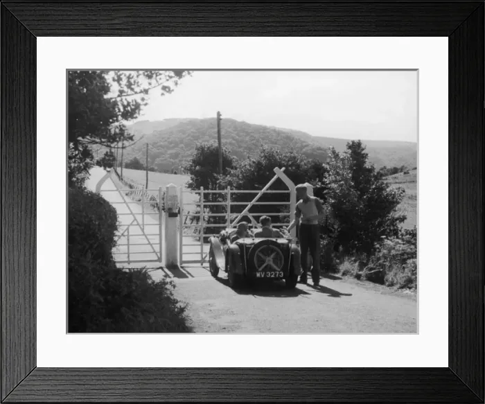 Framed Print : TOLL GATE. A young couple in an open-top sports car pay their dues at the Framed Print : TOLL GATE. A young couple in an open-top sports car pay their dues at the