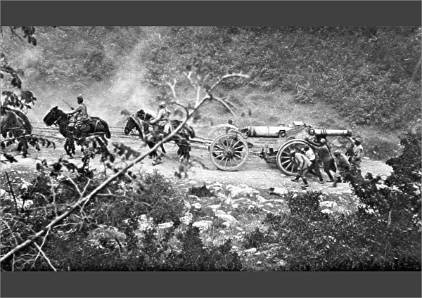 A heavy gun battery moving uphill during the Balkan campaign