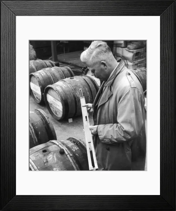 Framed Print : Customs Official checks the volume of wine in a barrel Framed Print : Customs Official checks the volume of wine in a barrel