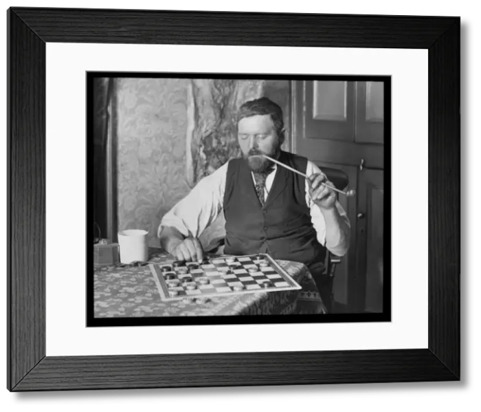 Framed Print : Man puzzling over a game of draughts Framed Print : Man puzzling over a game of draughts