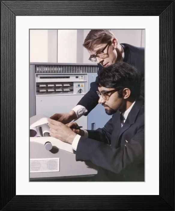 Framed Print : Two technicians check a computer printout Framed Print : Two technicians check a computer printout