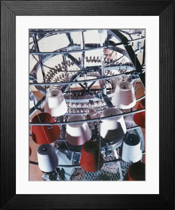 Framed Print : A machine collects coloured yarn onto rolls