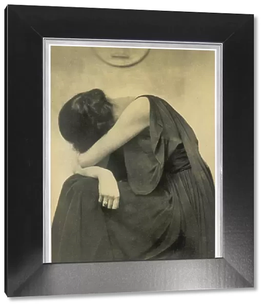 Grief. A woman holds her head in her arms in this camera study by Hugh