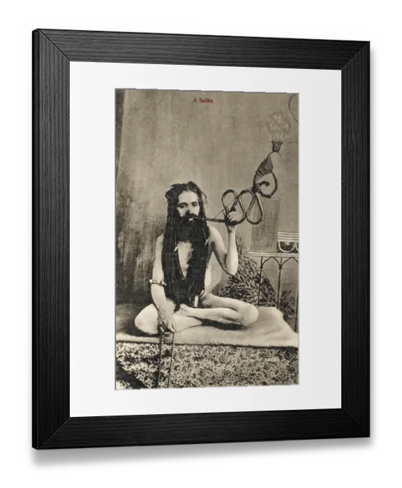 Framed Print : A Sadhu smoking a remarkable pipe, India Framed Print : A Sadhu smoking a remarkable pipe, India