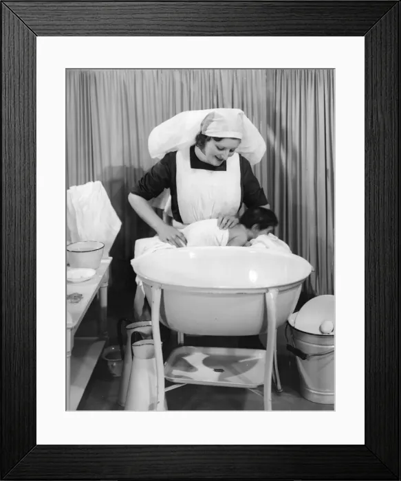 Framed Print : Nurse dries baby after bath Framed Print : Nurse dries baby after bath
