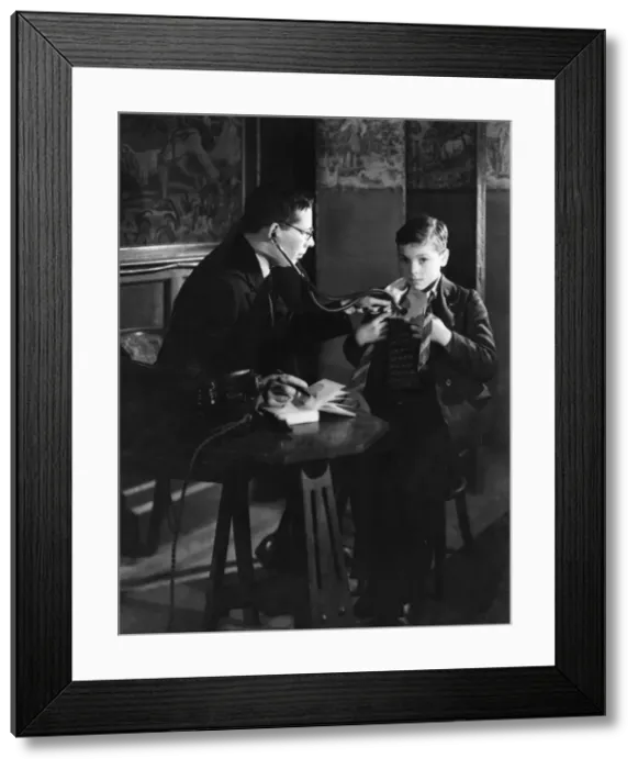 Framed Print : Doctor with stethoscope examines boy Framed Print : Doctor with stethoscope examines boy