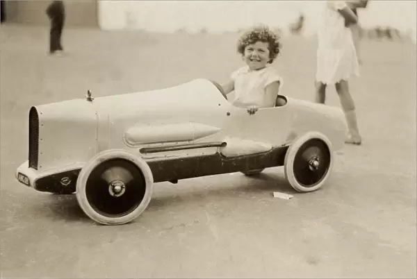 Young girl in model racing car