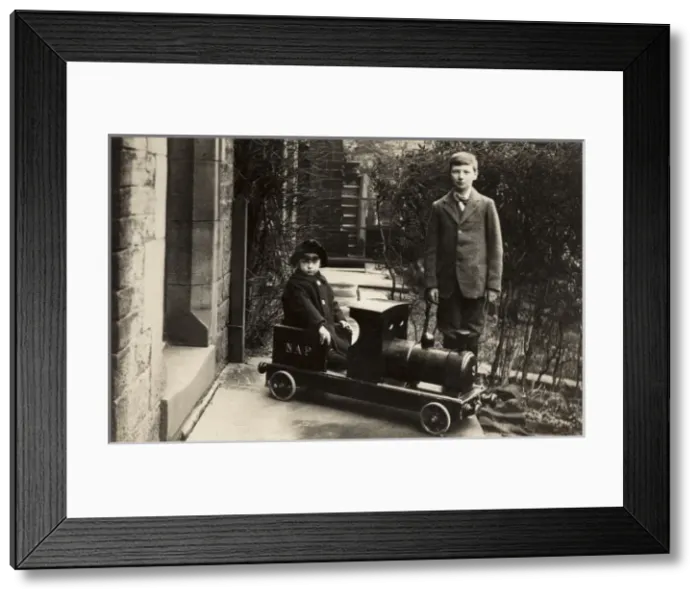 Framed Print : Young boy in a model train with his elder brother Framed Print : Young boy in a model train with his elder brother