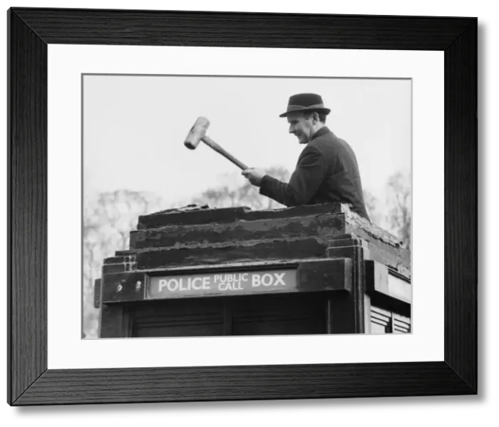 Framed Print : Man demolishing top of police public call box Framed Print : Man demolishing top of police public call box