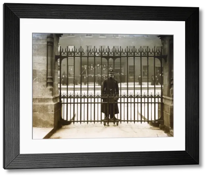 Framed Print : Met Police officer looking through iron gates Framed Print : Met Police officer looking through iron gates