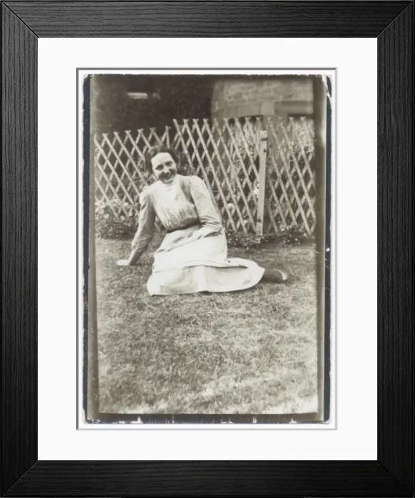 Framed Print : Smiling woman sitting on a lawn Framed Print : Smiling woman sitting on a lawn