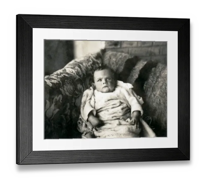 Framed Print : Cross looking baby on a sofa Framed Print : Cross looking baby on a sofa