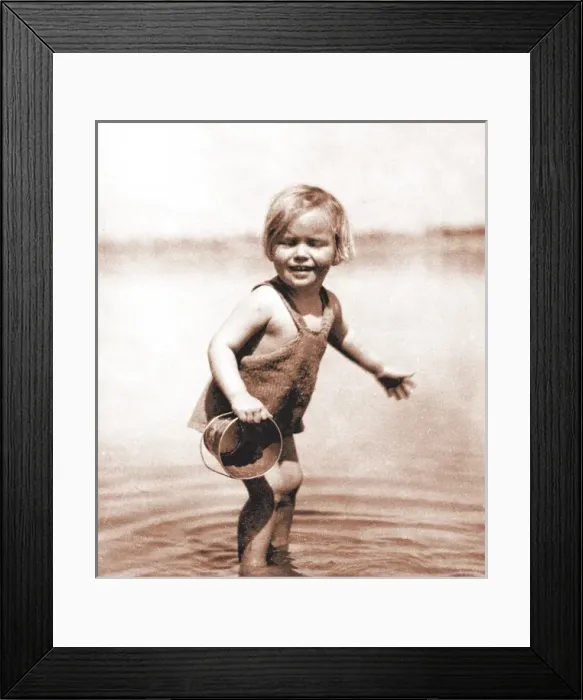 Framed Print : Little girl paddling, with bucket Framed Print : Little girl paddling, with bucket