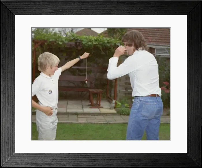 Framed Print : Boy and young man playing conkers in the garden Framed Print : Boy and young man playing conkers in the garden