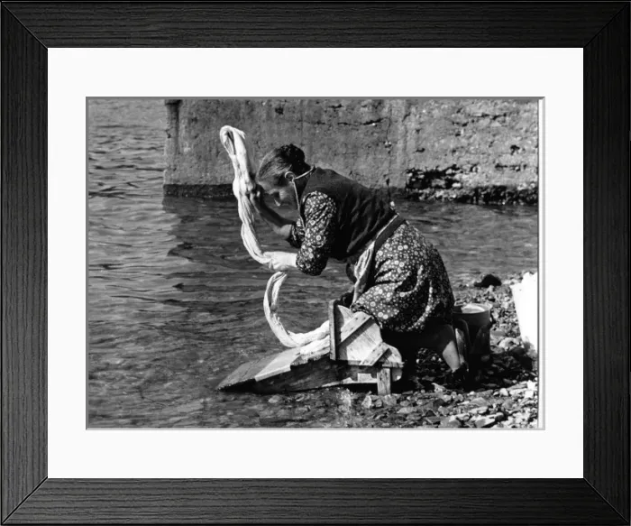 Framed Print : Woman washing a sheet in a river in Portugal Framed Print : Woman washing a sheet in a river in Portugal