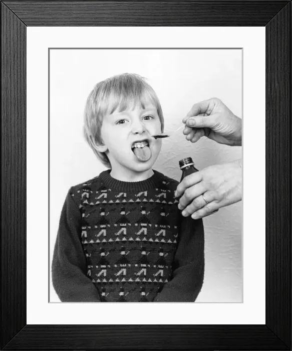 Framed Print : Little boy reluctantly taking his medicine Framed Print : Little boy reluctantly taking his medicine