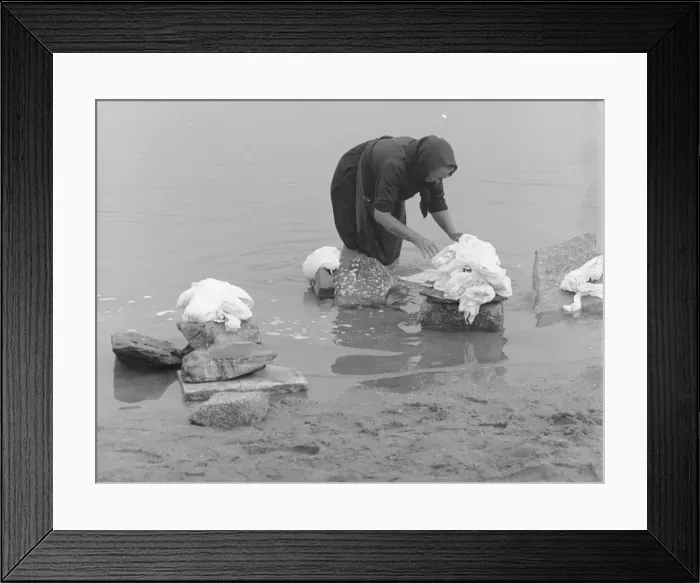 Framed Print : Woman sorting out washing in a river Framed Print : Woman sorting out washing in a river