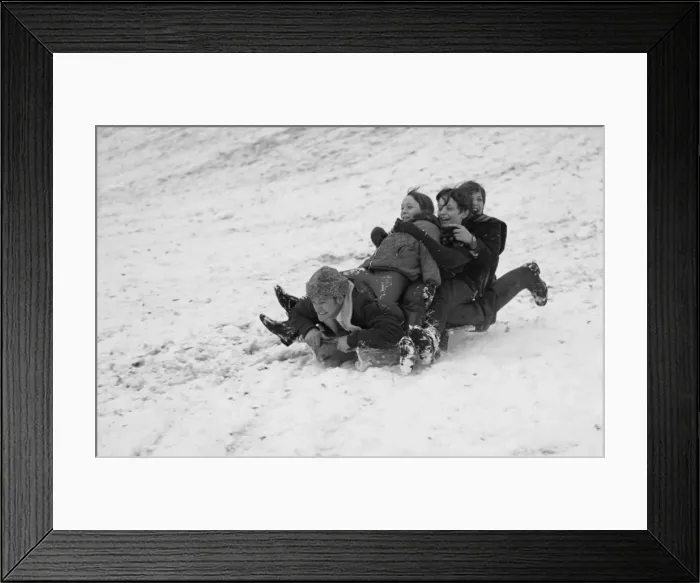 Framed Print : Man and three children on a toboggan in the snow Framed Print : Man and three children on a toboggan in the snow