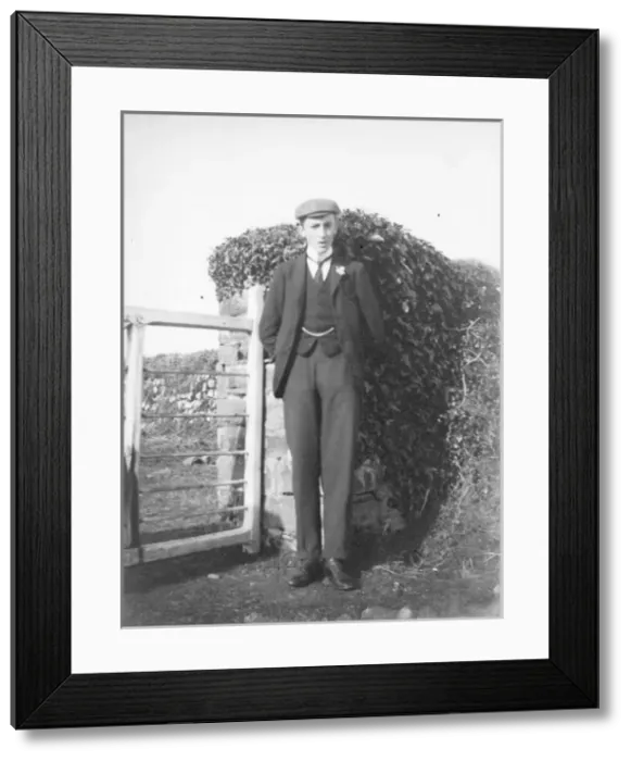 Framed Print : Young man standing by a gate Framed Print : Young man standing by a gate