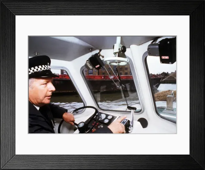 Framed Print : Policeman at the controls of a riverboat Framed Print : Policeman at the controls of a riverboat