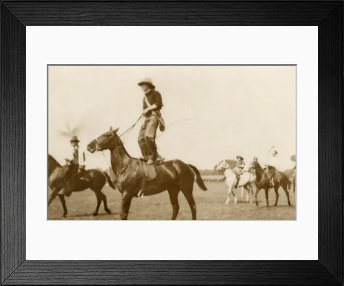 Framed Print : Cowboy riding on a horse, standing on its back Framed Print : Cowboy riding on a horse, standing on its back
