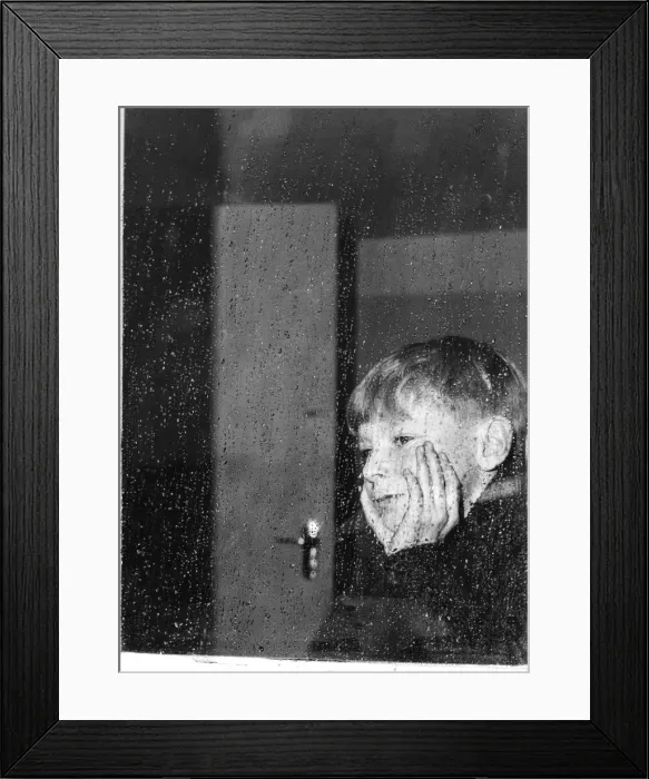 Framed Print : Boy looking through a window on a rainy day Framed Print : Boy looking through a window on a rainy day
