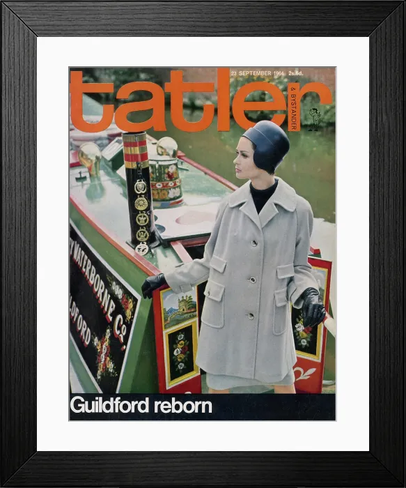 Framed Print : Tatler Front Cover - Woman in a grey doeskin jacket and navy leather helmet, standing on the colourfully painted canal boat Arcturus, moored on the River Wey in Guildford Framed Print : Tatler Front Cover - Woman in a grey doeskin jacket and navy leather helmet, standing on the colourfully painted canal boat Arcturus, moored on the River Wey in Guildford