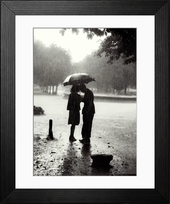 Framed Print : Atmospheric shot of young female-male couple under umbrella in rain in park, heads inclined to each other; has romantic feel Date: early 1950s Framed Print : Atmospheric shot of young female-male couple under umbrella in rain in park, heads inclined to each other; has romantic feel Date: early 1950s