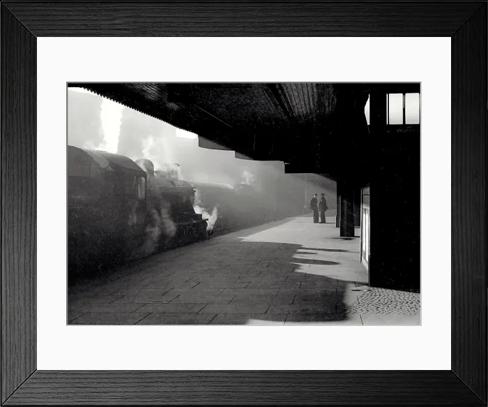 Framed Print : Atmospheric shot in station with strong diagonal light and silhouettes of train workers and train Date: early 1950s Framed Print : Atmospheric shot in station with strong diagonal light and silhouettes of train workers and train Date: early 1950s