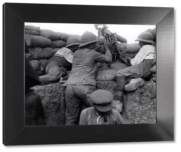 Soldiers in a trench, firing a machine gun, WW1