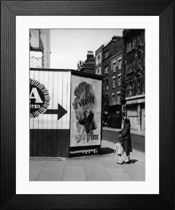 Framed Print : Contemplating a nutritional advice poster in London, 1940s Framed Print : Contemplating a nutritional advice poster in London, 1940s