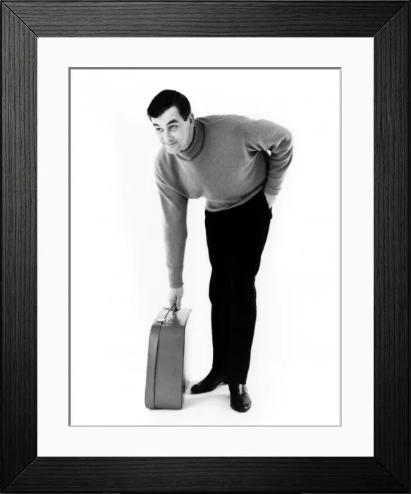 Framed Print : HEs OFF. A man picks up his suitcase. Date: late 1960s Framed Print : HEs OFF. A man picks up his suitcase. Date: late 1960s