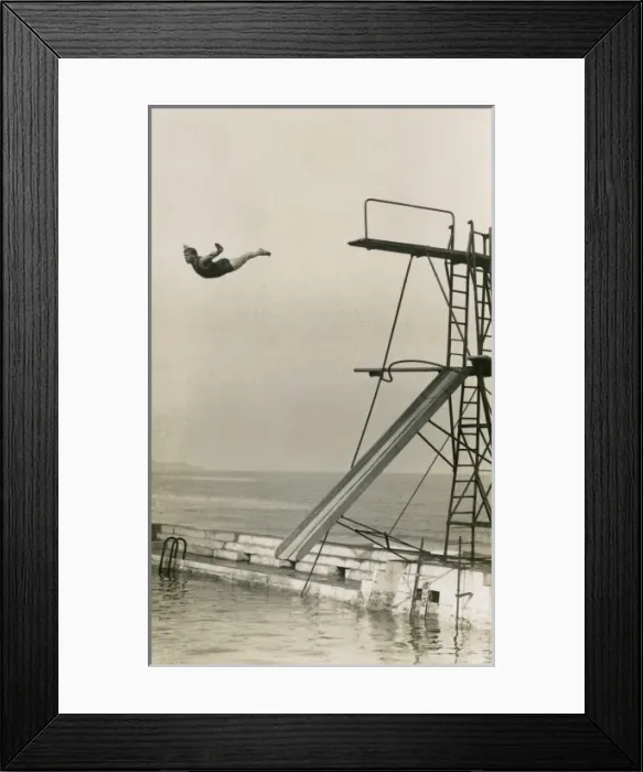 Framed Print : Man diving into an outdoor pool at a seaside resort Framed Print : Man diving into an outdoor pool at a seaside resort