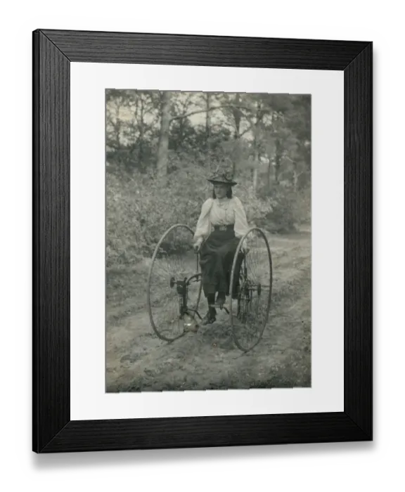 Framed Print : Young woman riding an early form of bicycle Framed Print : Young woman riding an early form of bicycle