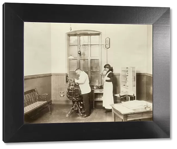 Dentist. A dentist and his nurse give a schoolboy his treatment, 1910 Date: c. 1910