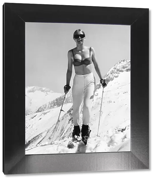 BRA SKIER. A rash young woman braves the ski slopes wearing just her bra and slacks