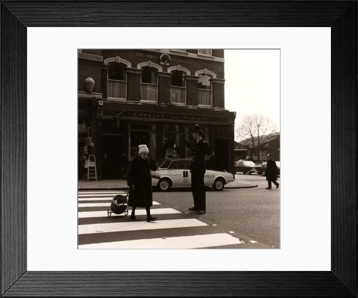 Framed Print : Policeman helping an old lady cross the road Framed Print : Policeman helping an old lady cross the road