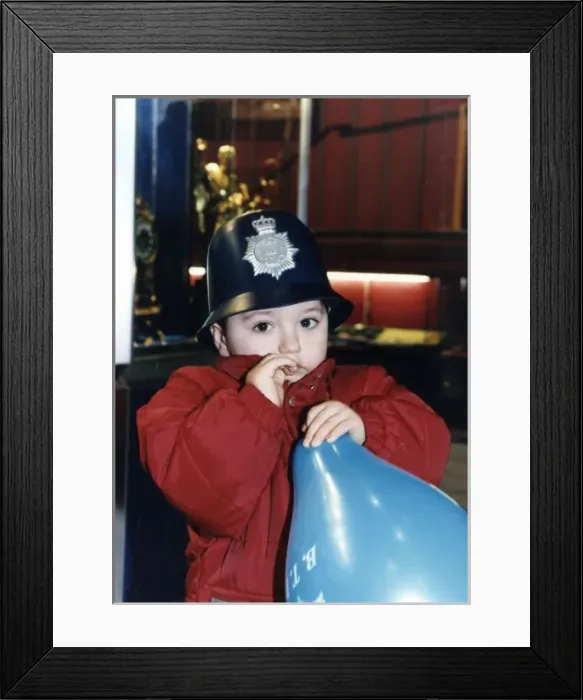 Framed Print : Little boy with balloon, wearing policemans helmet Framed Print : Little boy with balloon, wearing policemans helmet