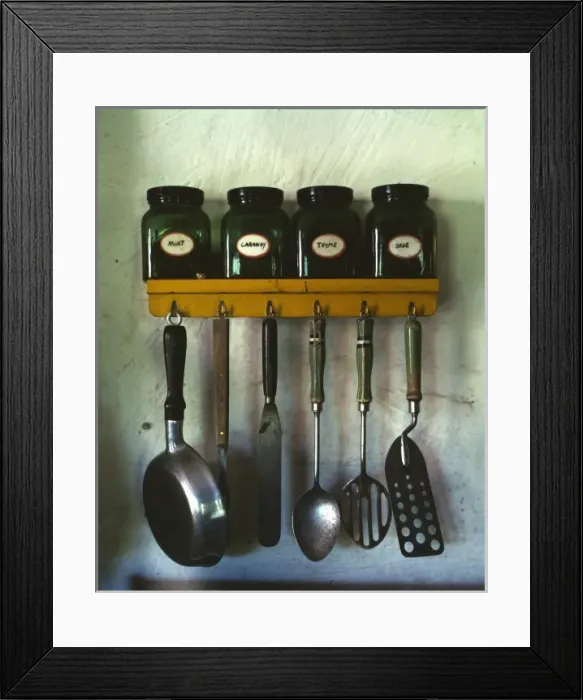 Framed Print : Kitchen utensils hanging below a spice rack with mint, caraw Framed Print : Kitchen utensils hanging below a spice rack with mint, caraw