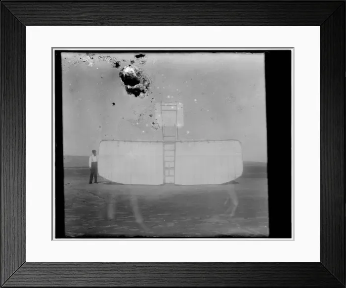 Framed Print : Orville at left wing end of upended glider, bottom view; Kit Framed Print : Orville at left wing end of upended glider, bottom view; Kit