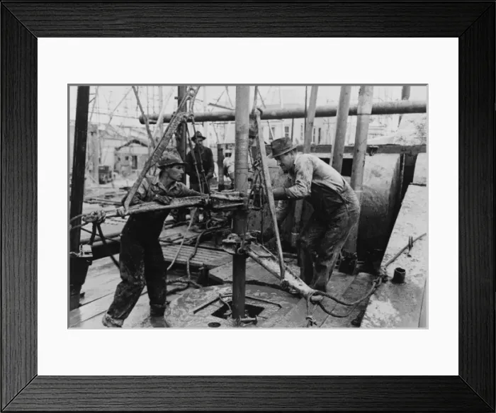 Framed Print : Oil roughnecks screwing one piece of drill pipe to another p Framed Print : Oil roughnecks screwing one piece of drill pipe to another p