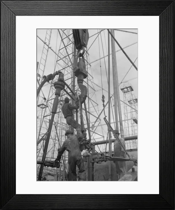 Framed Print : Activity at oil well; man on lengths of traveling block will Framed Print : Activity at oil well; man on lengths of traveling block will